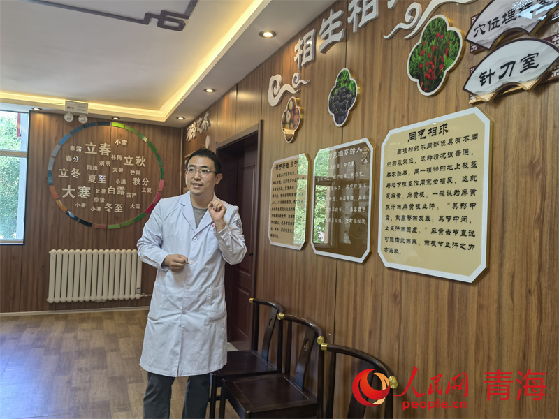 馬房健正在為來訪者介紹衛生院的特色診療服務。人民網馬可欣攝